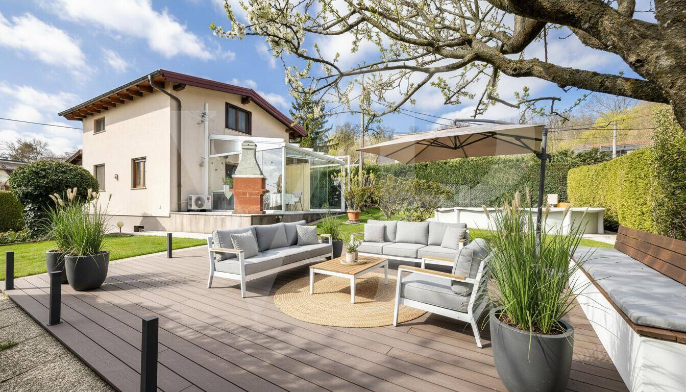 Große Holzterrasse mit modernen Gartenmöbeln und Blick auf das Haus und den Garten.