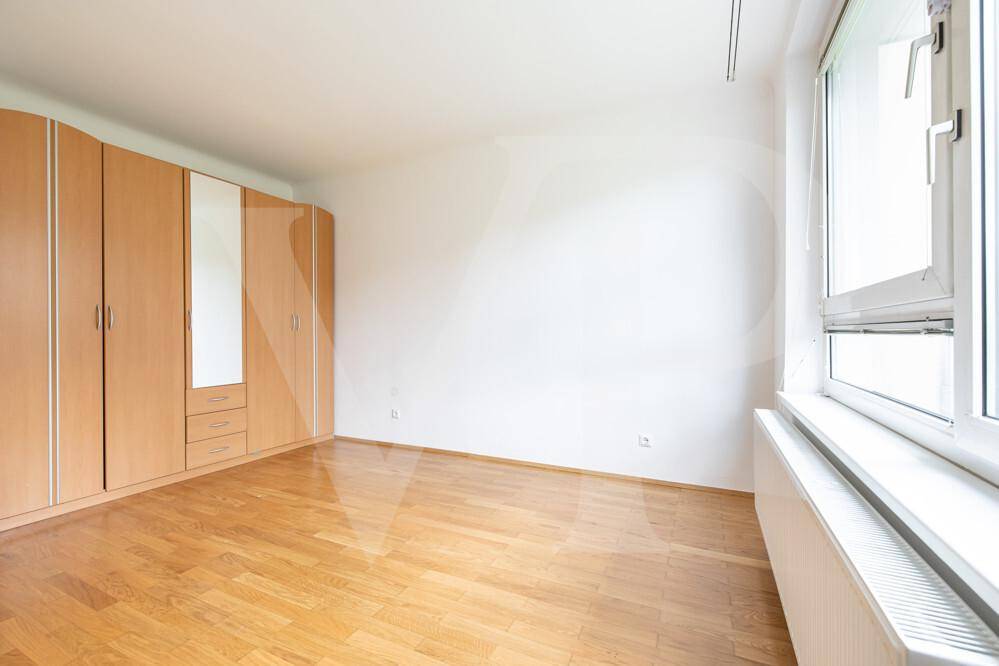 Geräumiges Schlafzimmer mit Parkettboden und großem Spiegelschrank.
