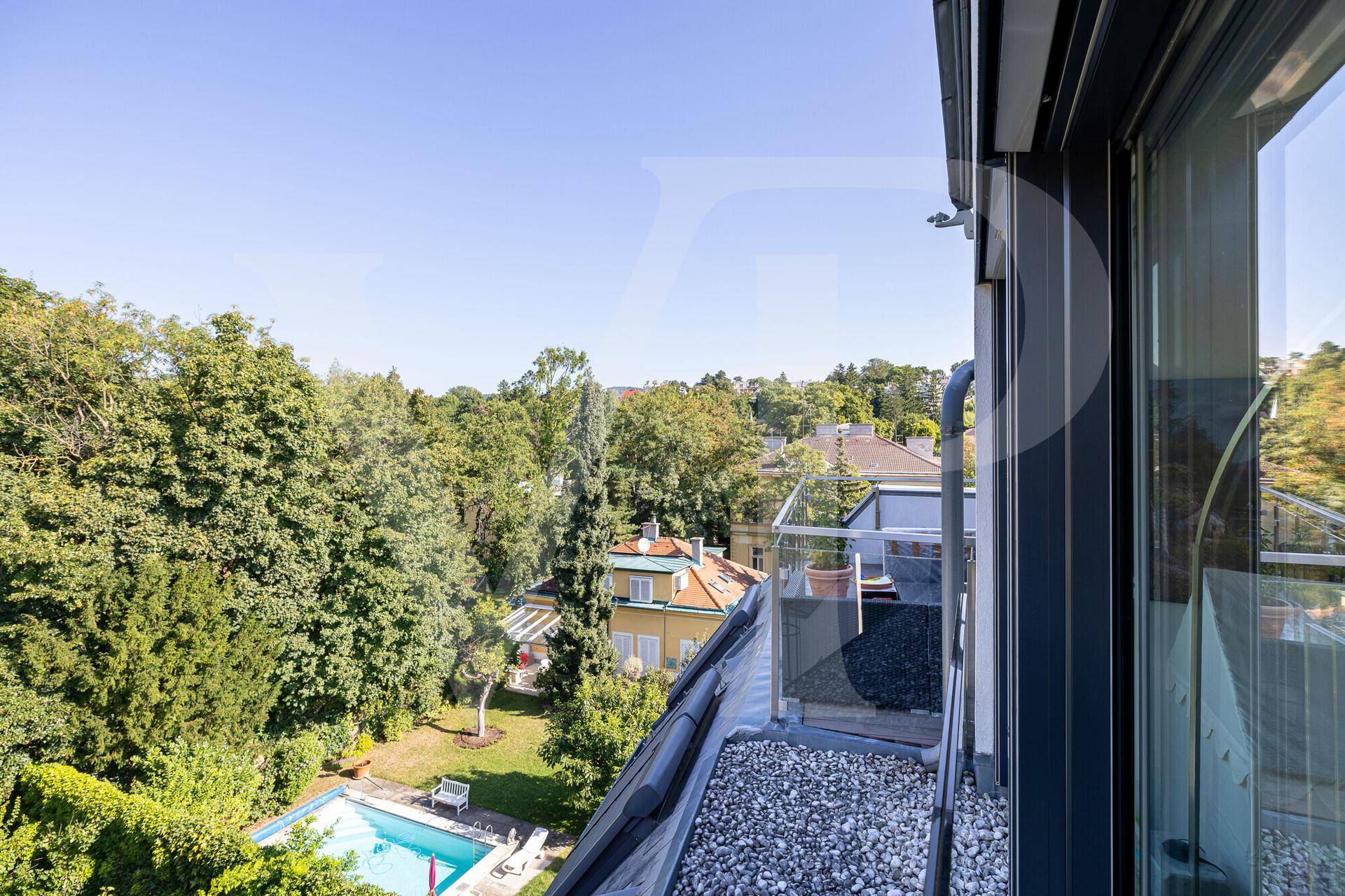 Balkon mit Blick auf eine grüne Umgebung und einen privaten Pool in der Ferne.