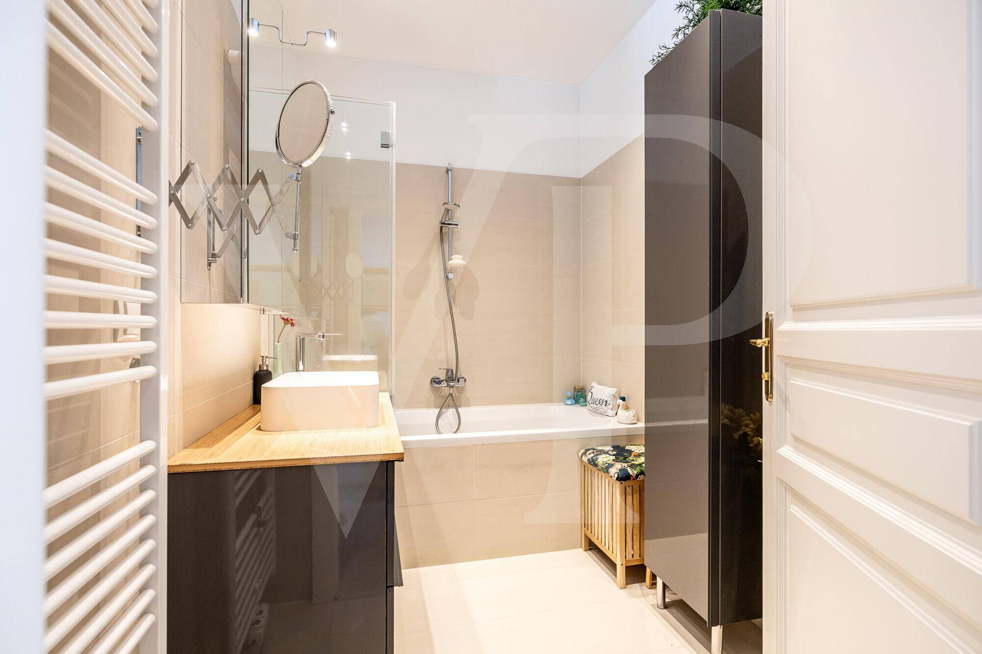 Modernes Badezimmer mit Badewanne, Dusche und beheiztem Handtuchhalter.