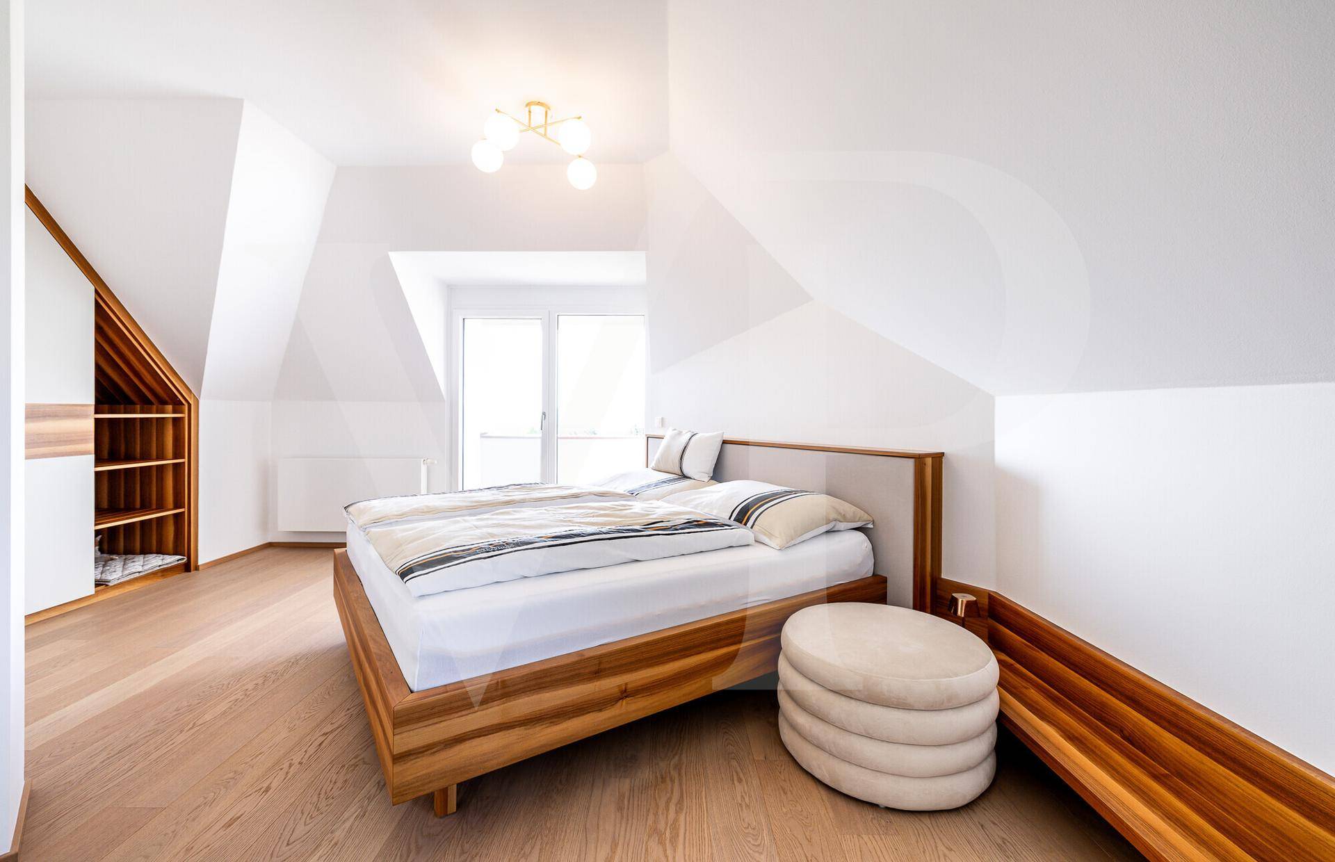 Gemütliches Schlafzimmer im Dachgeschoss mit Holzbett, Dachschrägen und Holzboden.
