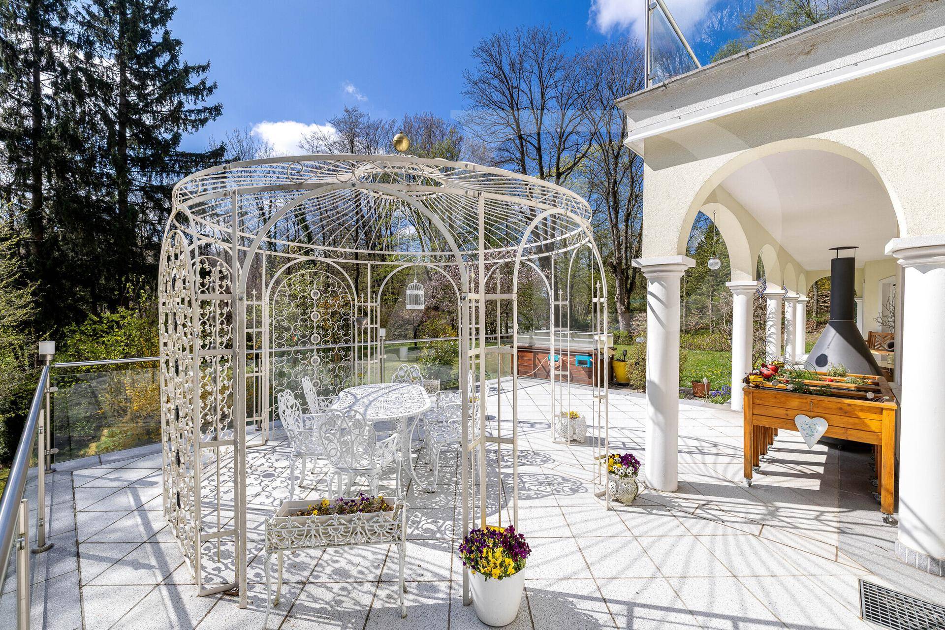 Großzügige Sonnenterrasse mit elegantem Pavillon, Außenkamin und Fliesenboden.