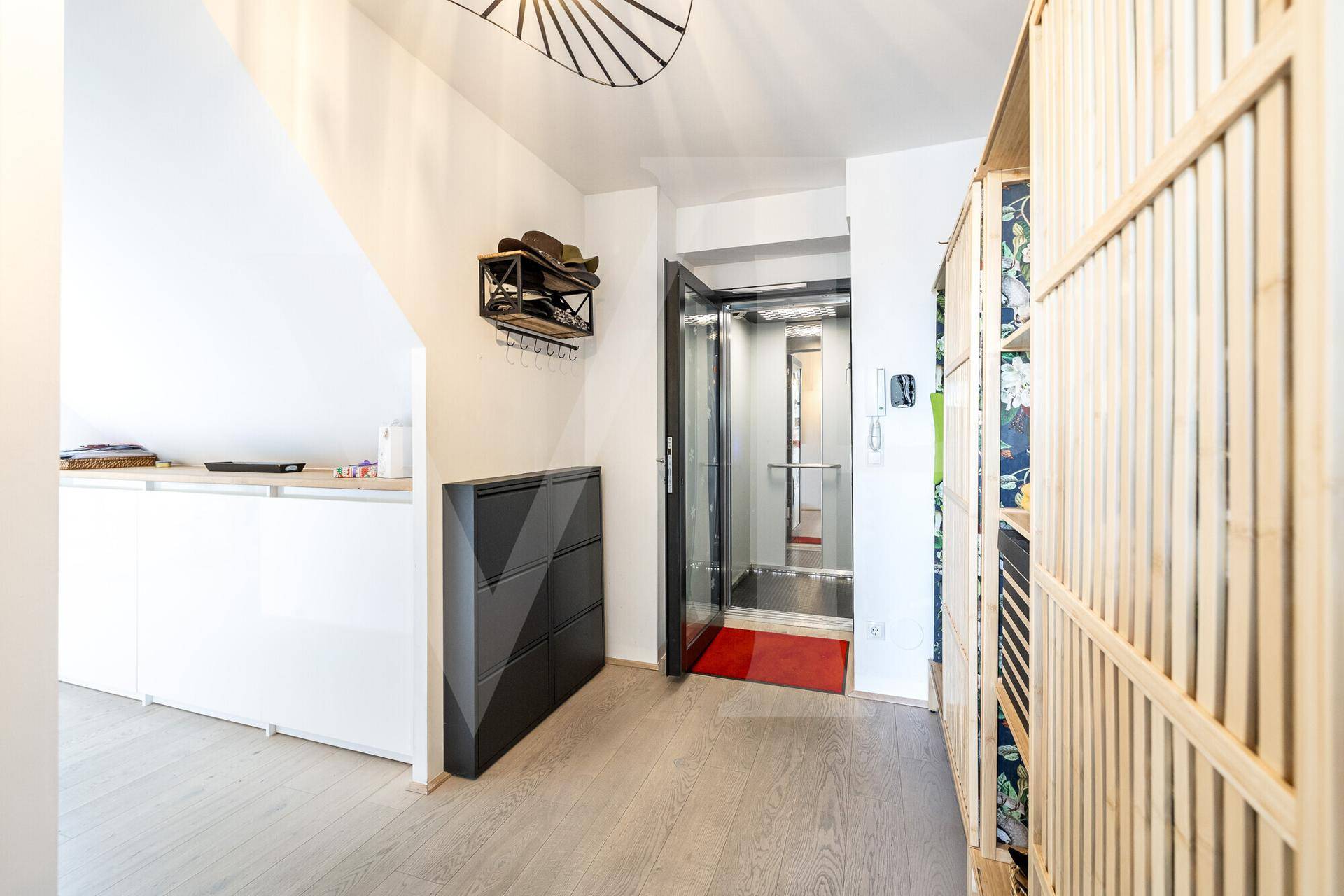 Heller Eingangsbereich mit privatem Lift und Holzfußboden.