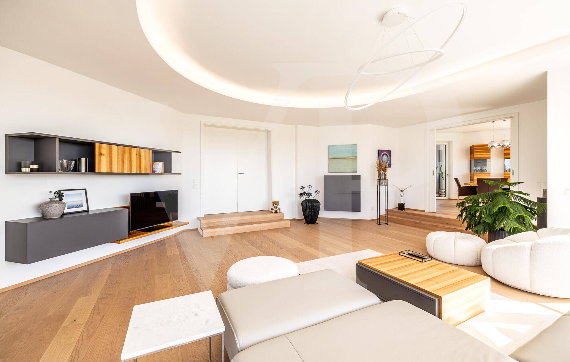 Geräumiges Wohnzimmer mit Holzboden, moderner Einrichtung und offenem Zugang zum Essbereich.