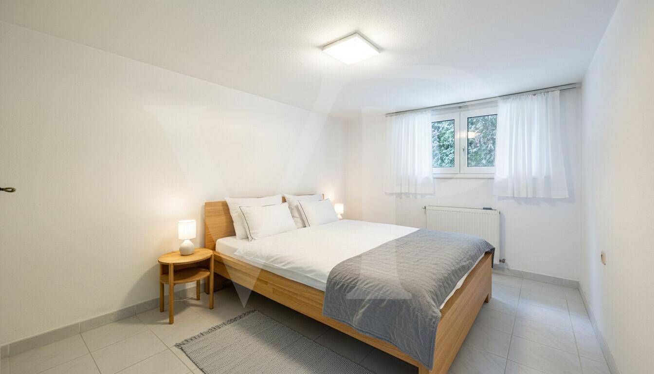 Gemütliches Schlafzimmer mit Holzbett und Fenster mit Blick ins Grüne.