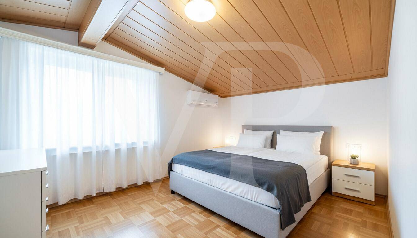 Schlafzimmer mit Doppelbett, Holzdecke, Parkettboden und Klimaanlage.