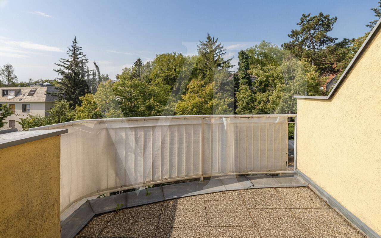 Leerer Balkon mit Blick ins Grüne, umgeben von Bäumen und Natur.