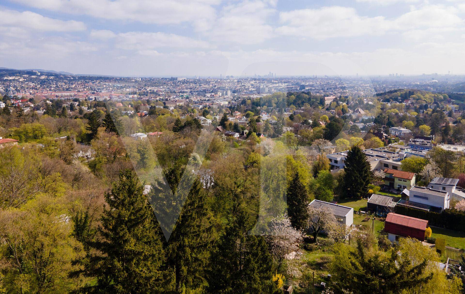 Weitläufiger Blick über die Stadt und die umliegende grüne Hügellandschaft.
