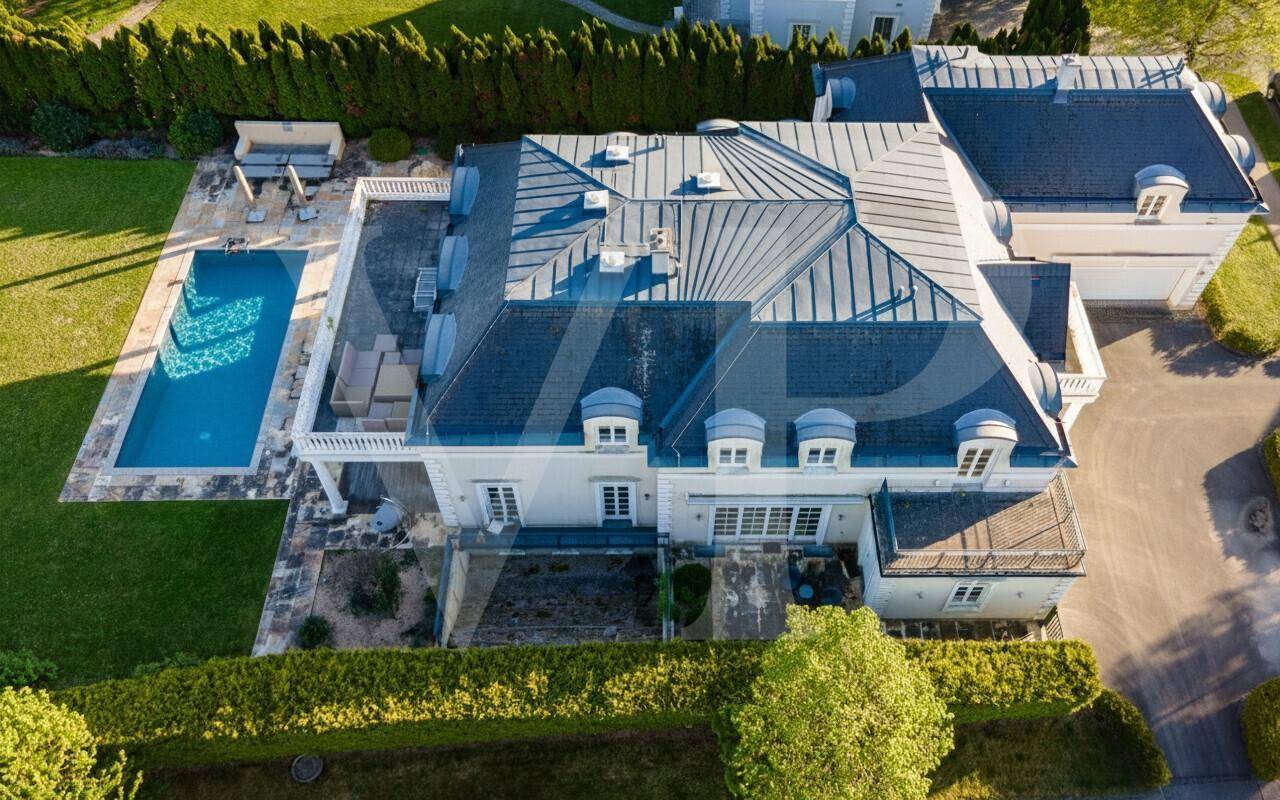 Luftaufnahme der luxuriösen Villa mit großem Poolbereich und gepflegtem Garten.