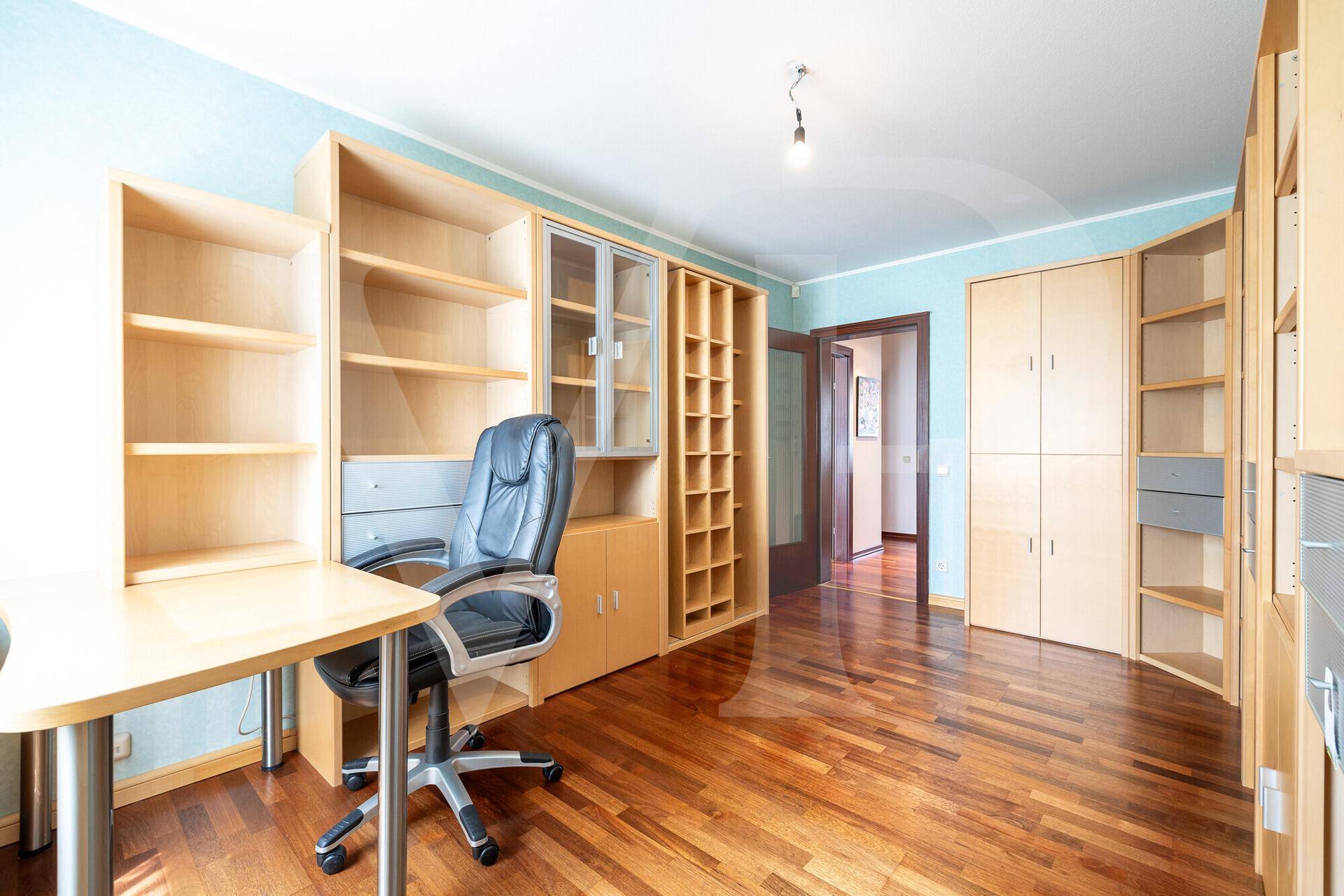 Funktionales Arbeitszimmer mit integrierten Holzregalen und Schreibtisch für produktives Arbeiten.