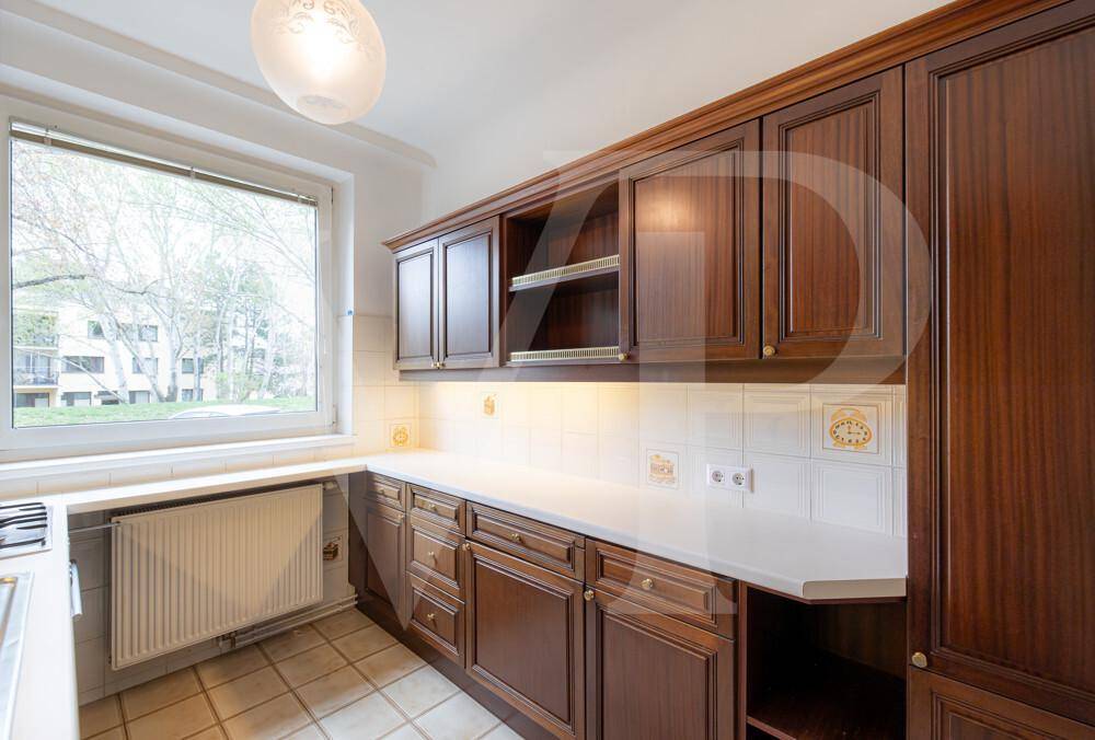 Traditionelle Küche mit Holzschränken, Arbeitsplatte und Fenster mit Ausblick.