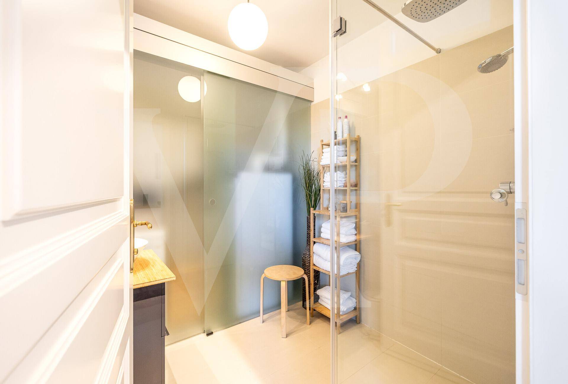Modernes Badezimmer mit begehbarer Dusche und Schiebetür.