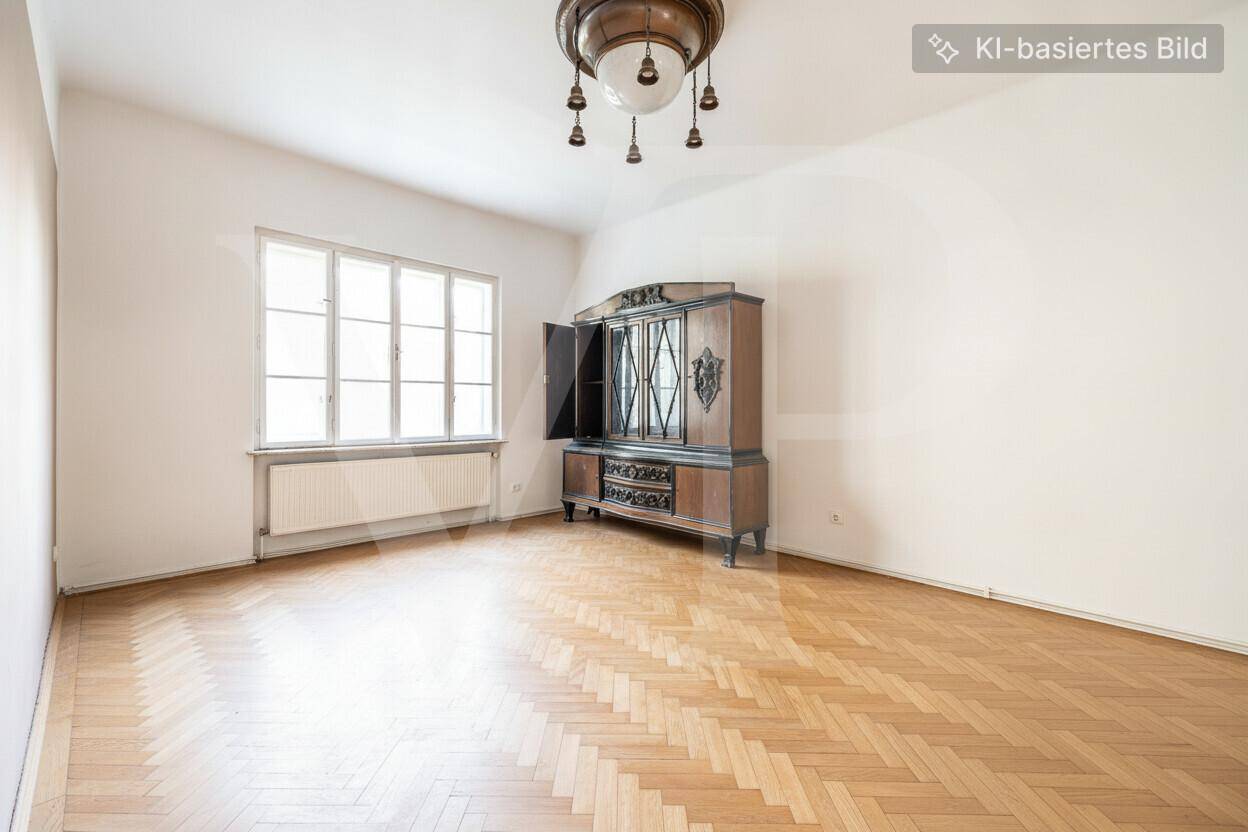 Zimmer mit Fischgrätparkett, großem Fenster, antikem Holzschrank und einer dekorativen Deckenleuchte.