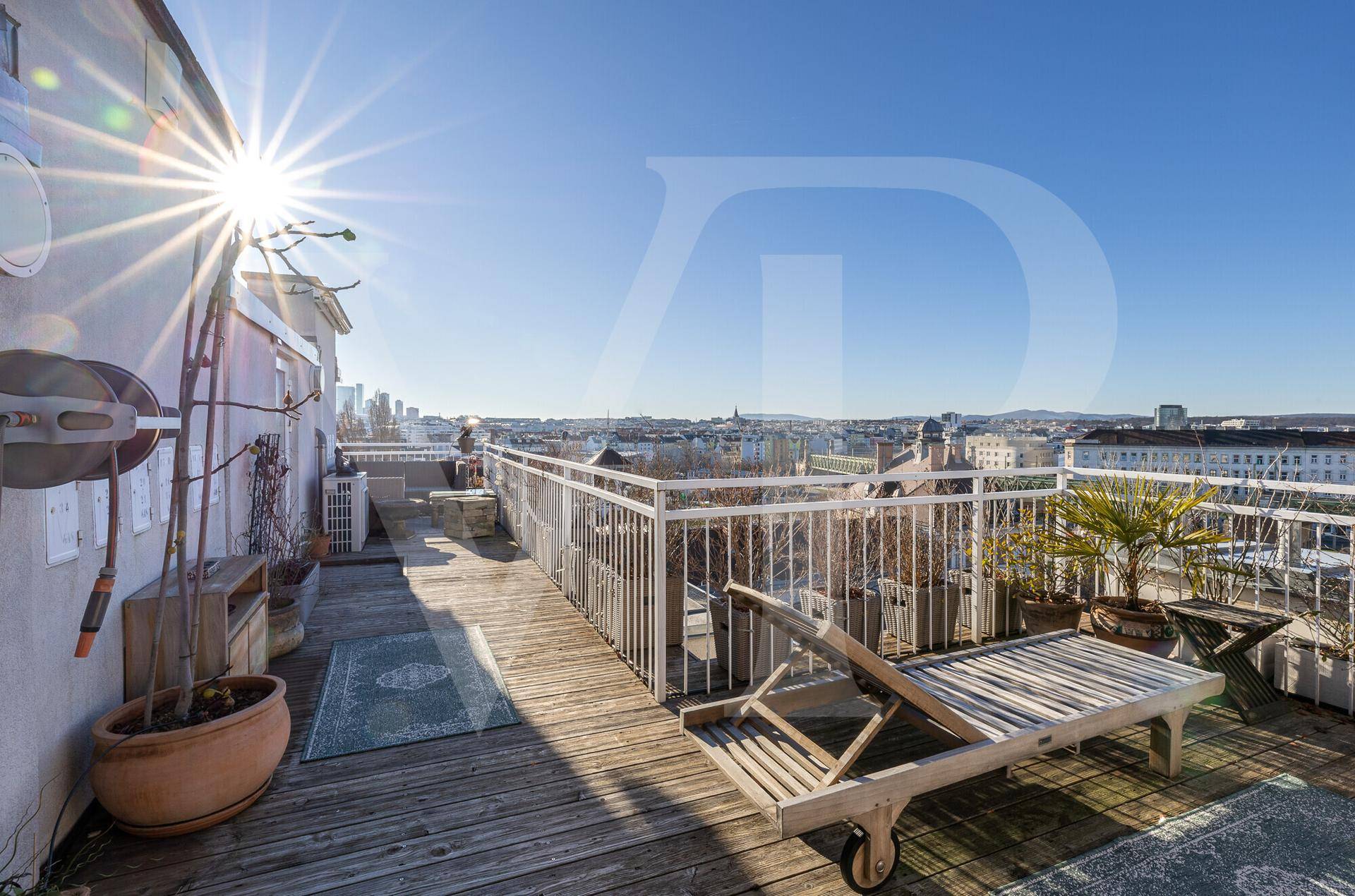 Große sonnige Dachterrasse mit Holzdeck und weitem Stadtpanorama.