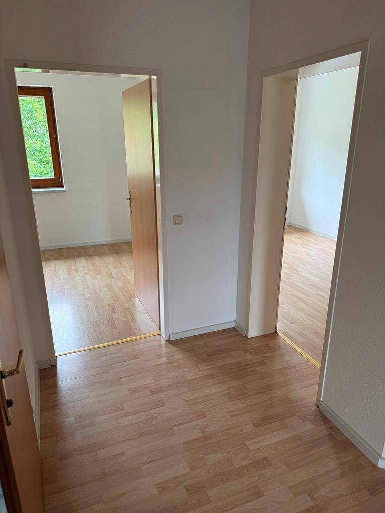 Heller Flur mit Laminatboden und Zugängen zu verschiedenen Zimmern.
