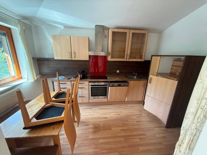 Helle Einbauküche mit Holzfronten, modernen Geräten und Laminatboden.