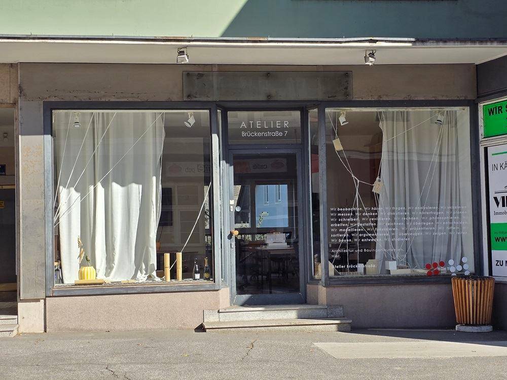 Eingangsbereich eines Geschäfts mit großen Schaufenstern und der Aufschrift "ATELIER Brückenstraße 7".