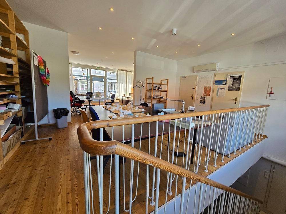 Offener Arbeitsbereich mit Holztreppe, Regalen und Blick auf den unteren Bereich.
