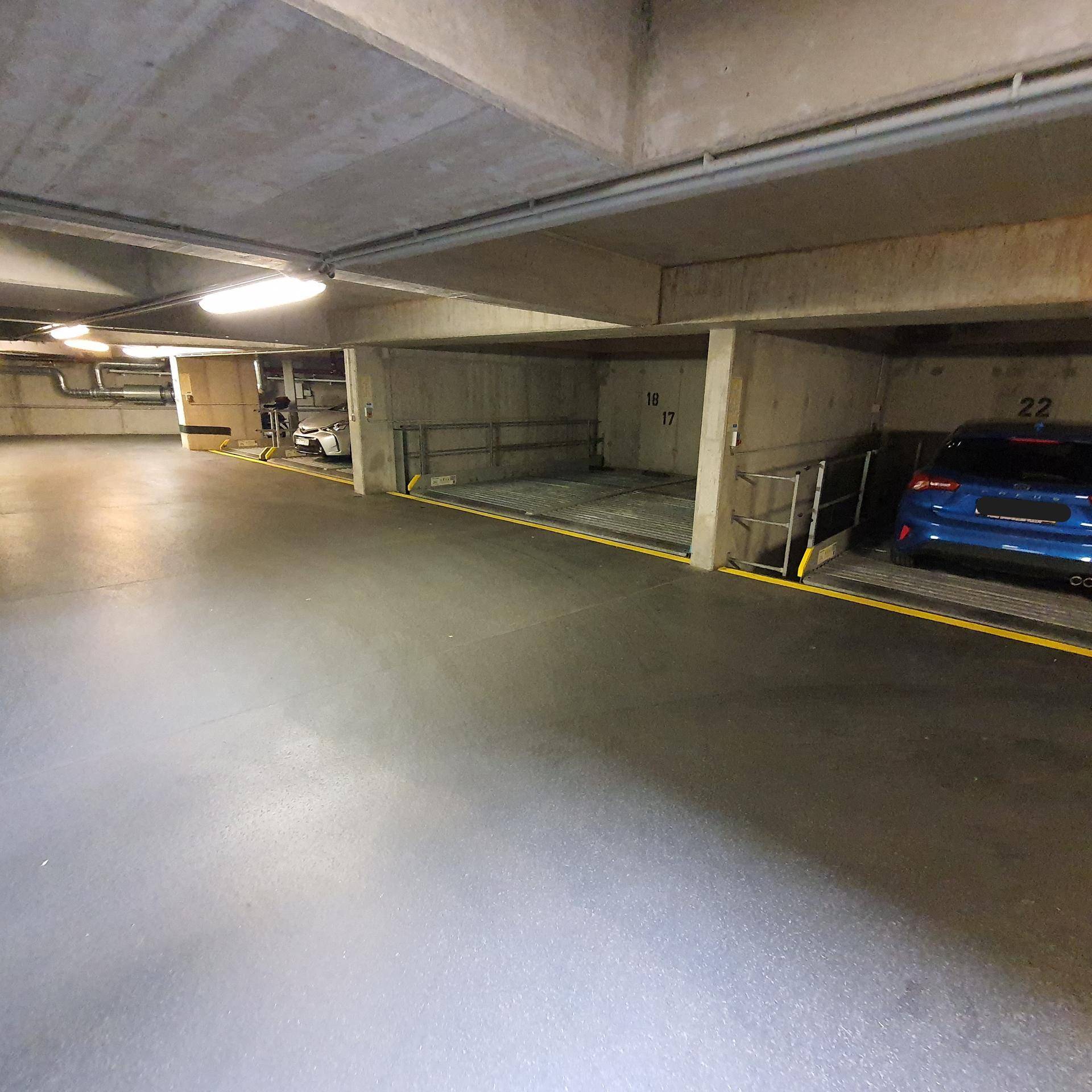 Geräumige Tiefgarage mit modernen Parksystemen und Betonkonstruktion.