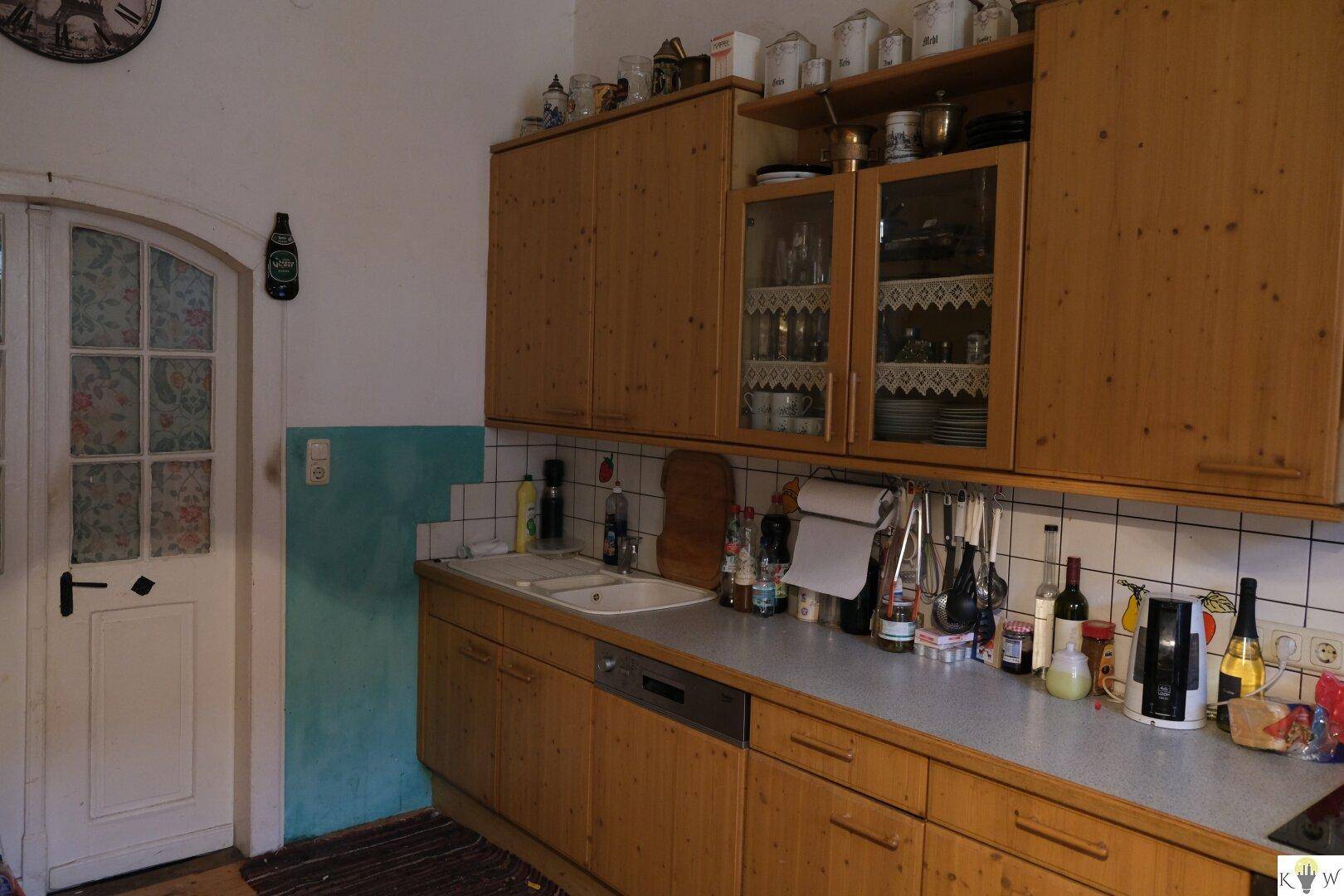 Rustikale Küche mit Holzschränken, weißer Fliesenrückwand und einer Spülmaschine.