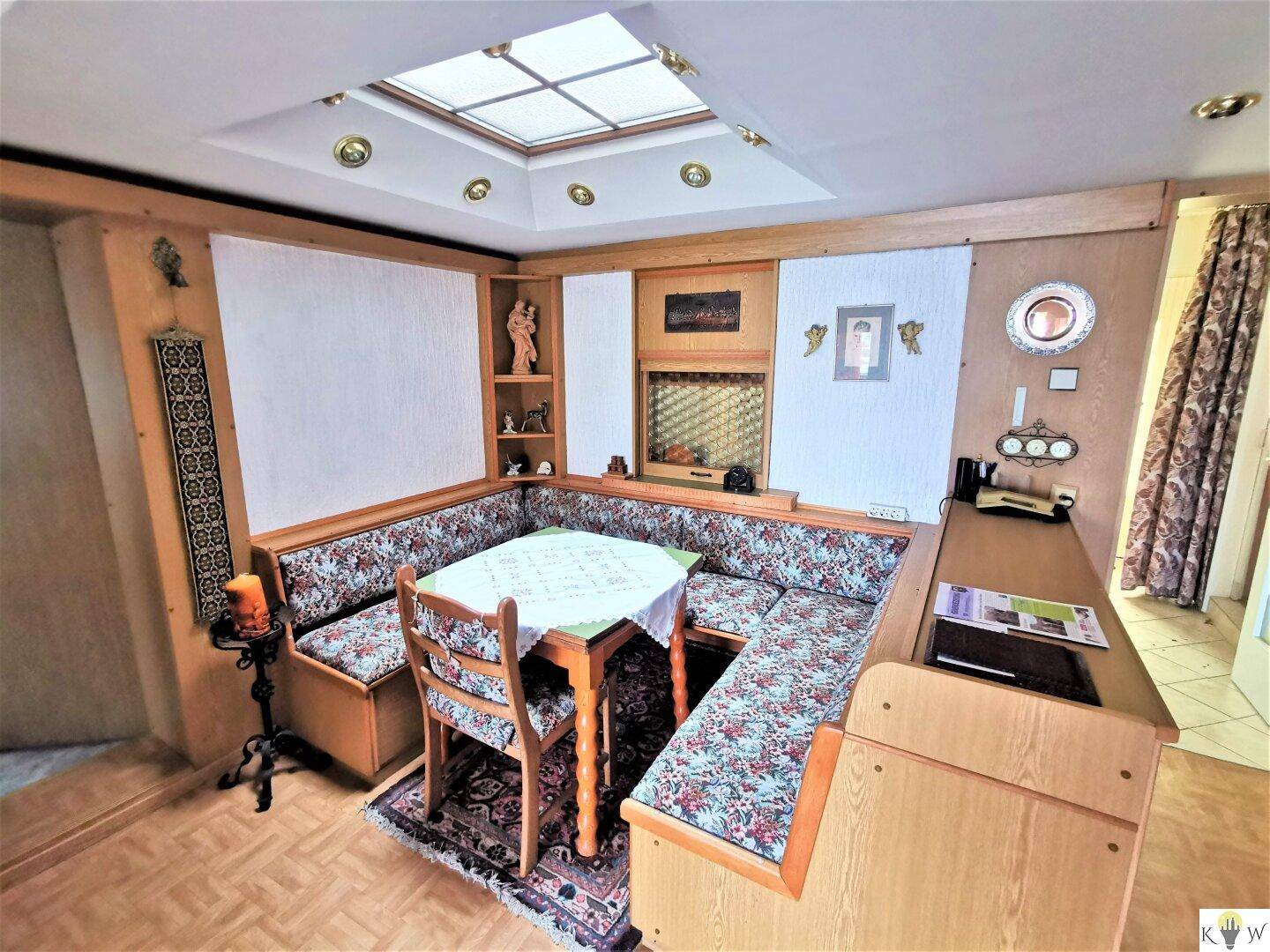 Traditionelle Essecke mit gepolsterter Eckbank, Holztisch und dekorativem Dachfenster.