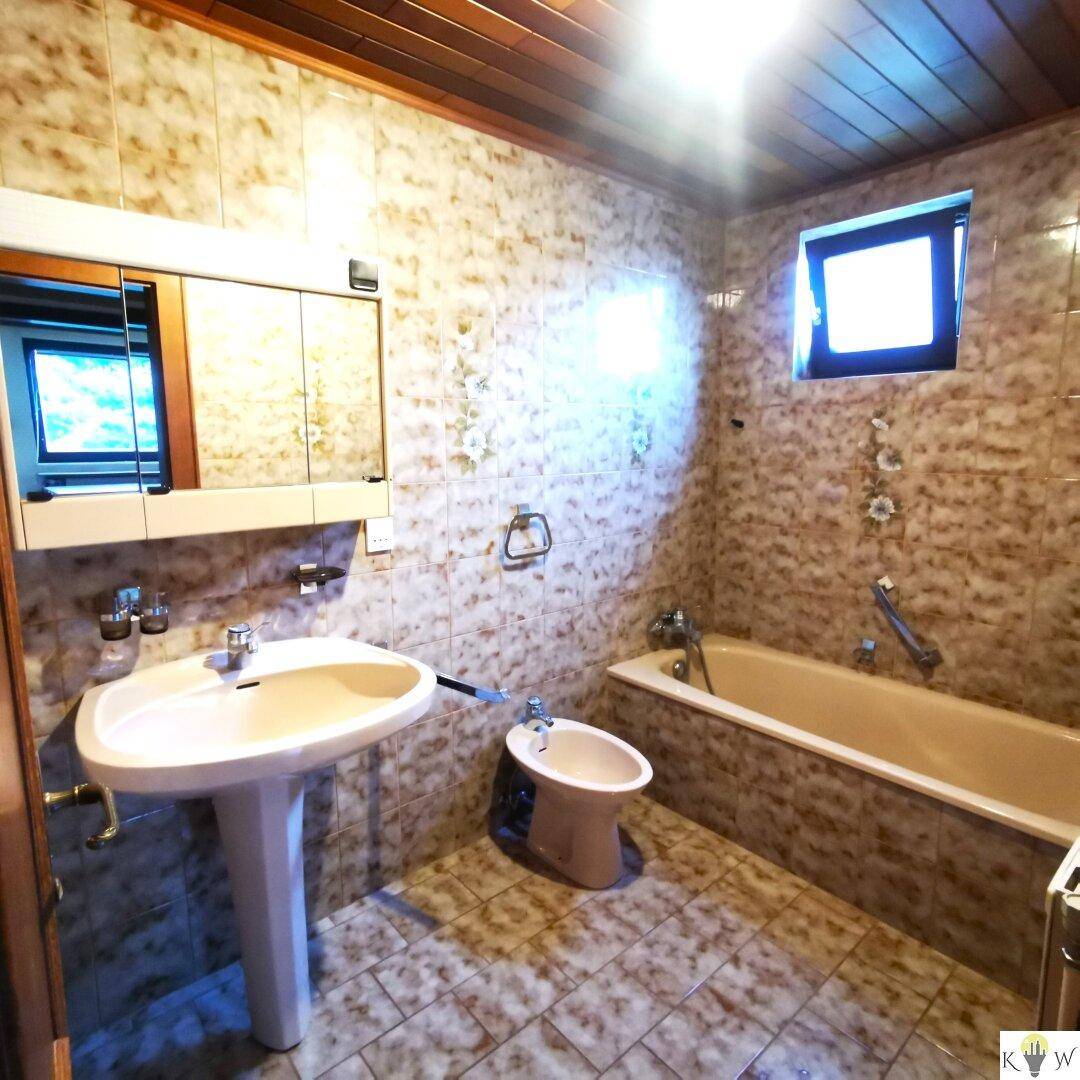 Badezimmer mit Badewanne, Bidet, Waschbecken und Fenster für Belüftung.