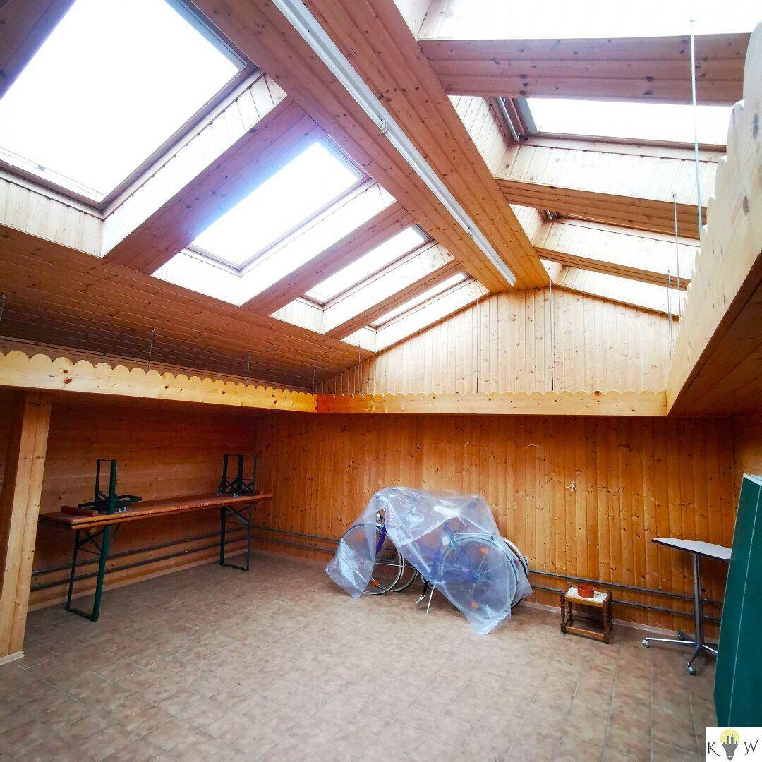 Geräumiger Dachboden mit Holzverkleidung, Dachfenstern und viel Tageslicht.