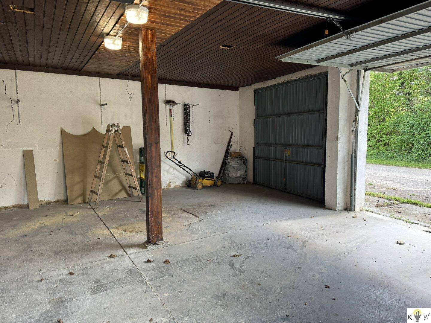 Geräumige Garage mit Betonboden und Werkzeugen, ideal für Heimwerker.
