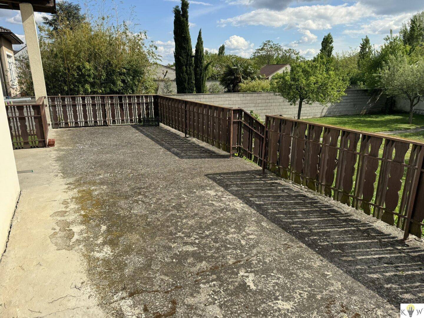 Große, unmöblierte Terrasse mit Holzgeländer und Blick ins Grüne.
