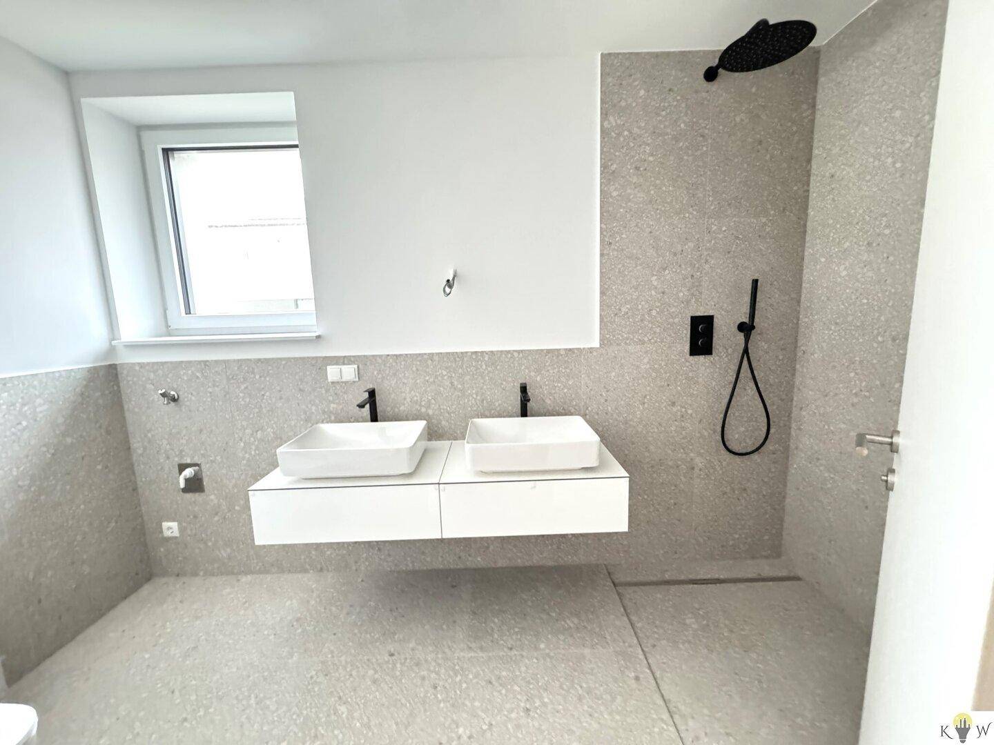 Modernes Badezimmer mit doppelter Waschtischanlage, begehbarer Dusche und Fenster für Tageslicht.