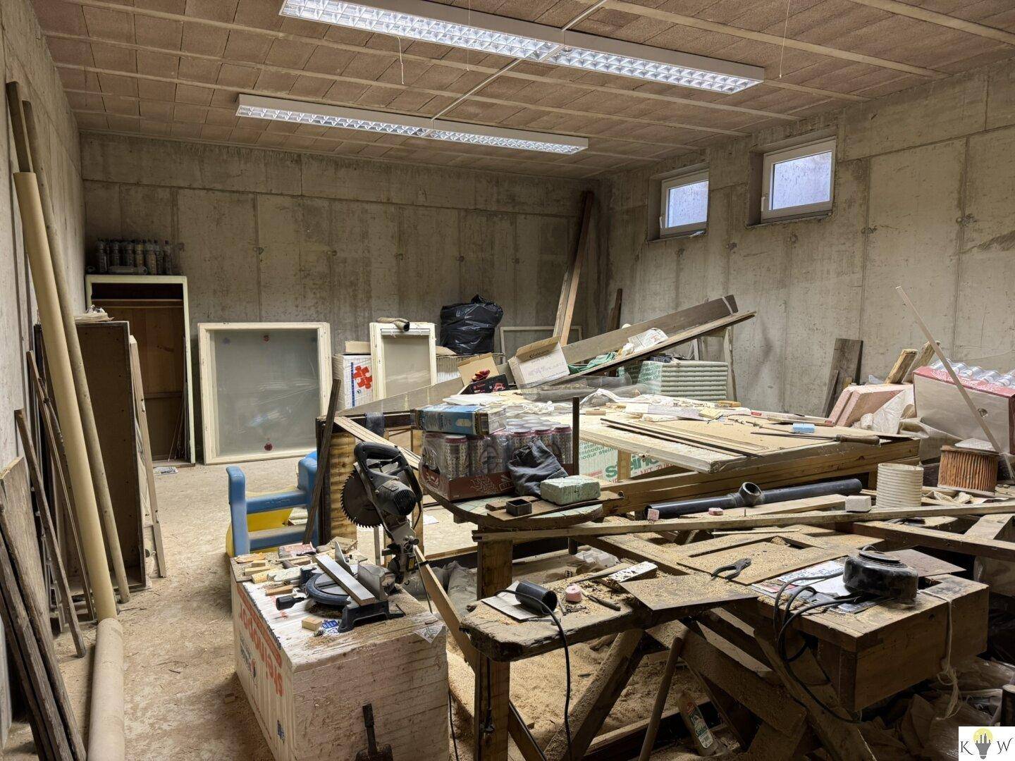 Werkstatt oder Lagerraum im Keller mit Werkzeugen und Baumaterialien.