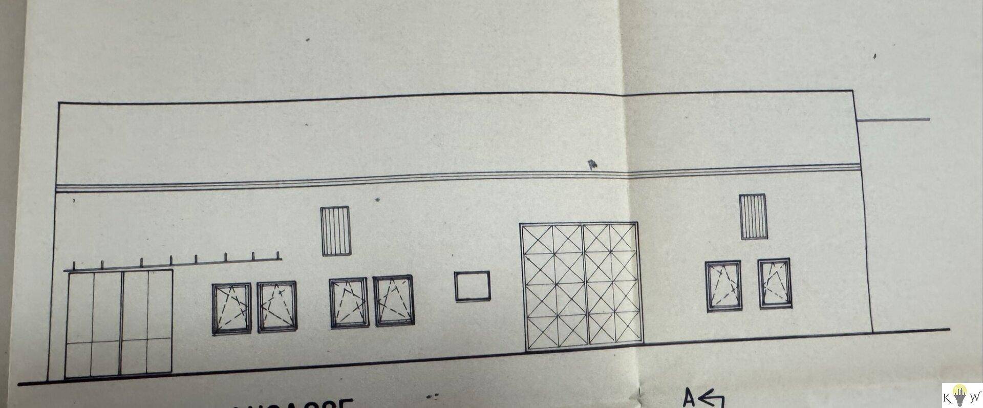 Fassadenansicht des Gebäudes mit Fenstern und einem großen Gitterelement.