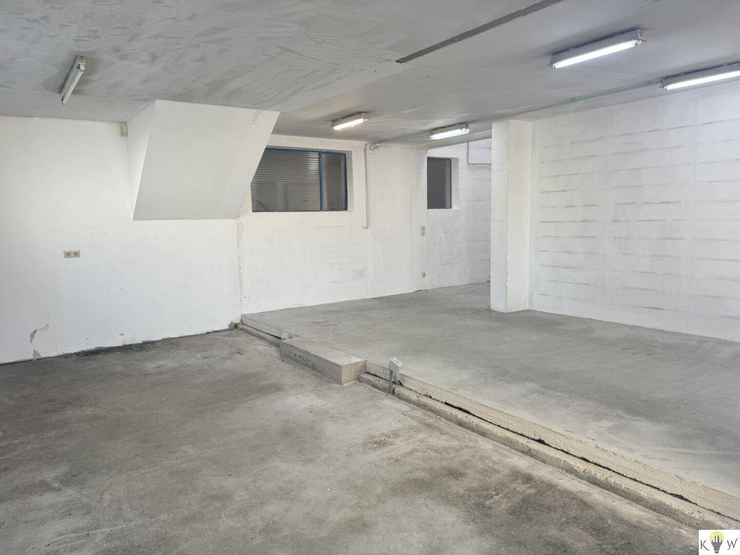 Großer, leerer Lagerraum mit Betonboden und hohen Decken, bereit zur Nutzung.