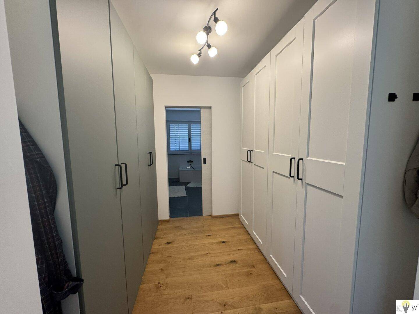 Geräumiges Ankleidezimmer mit vielen Einbauschränken und Holzboden.
