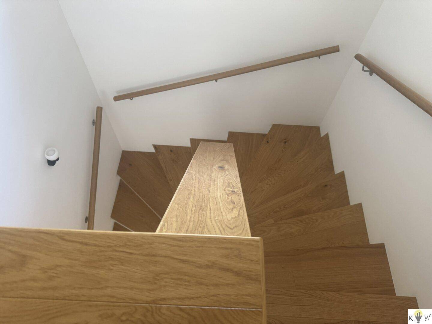 Moderne Holztreppe mit Geländer, die die verschiedenen Etagen des Hauses verbindet.