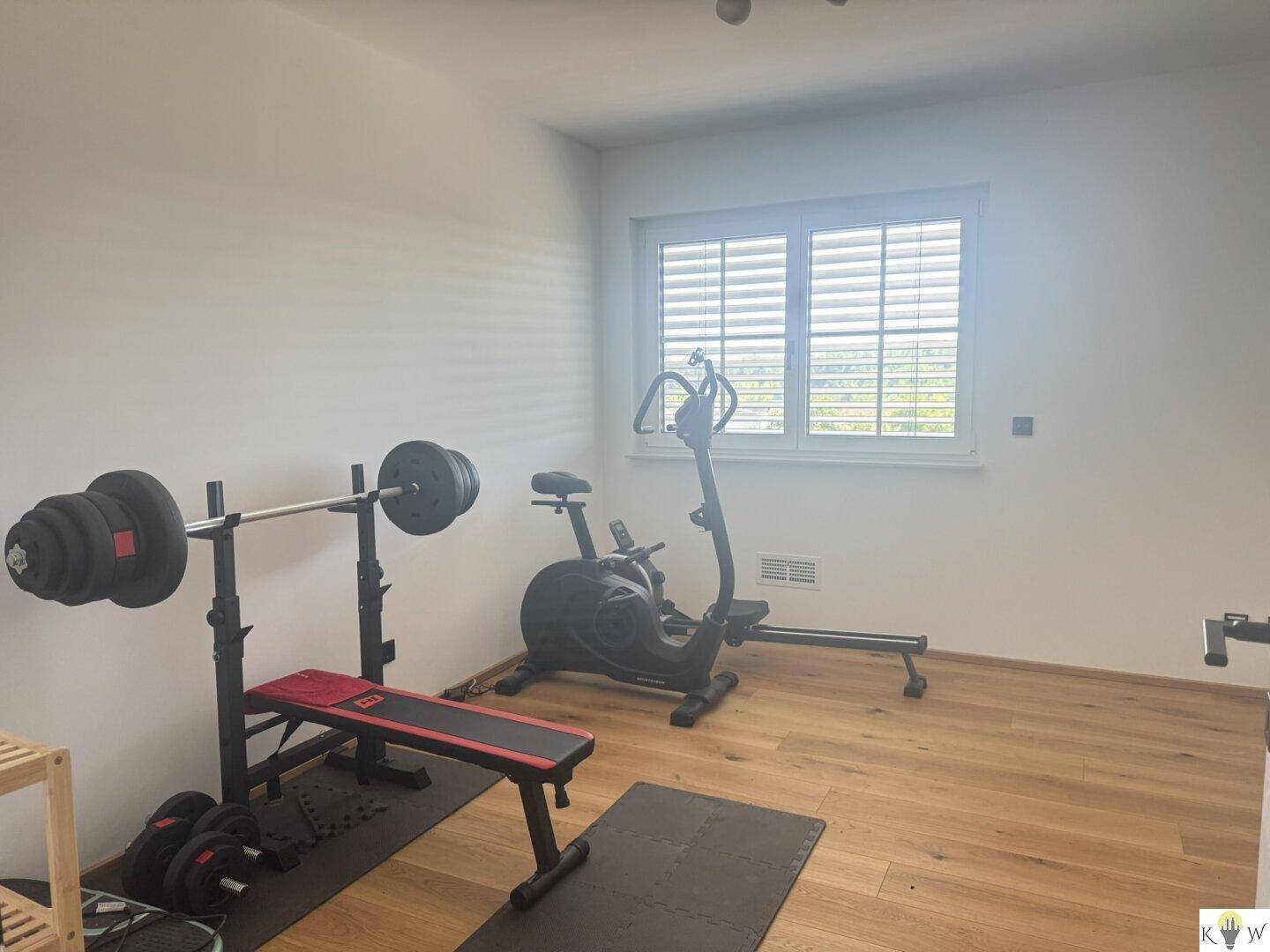 Heller Raum mit Fitnessgeräten, ideal für ein privates Heim-Fitnessstudio mit viel Tageslicht.