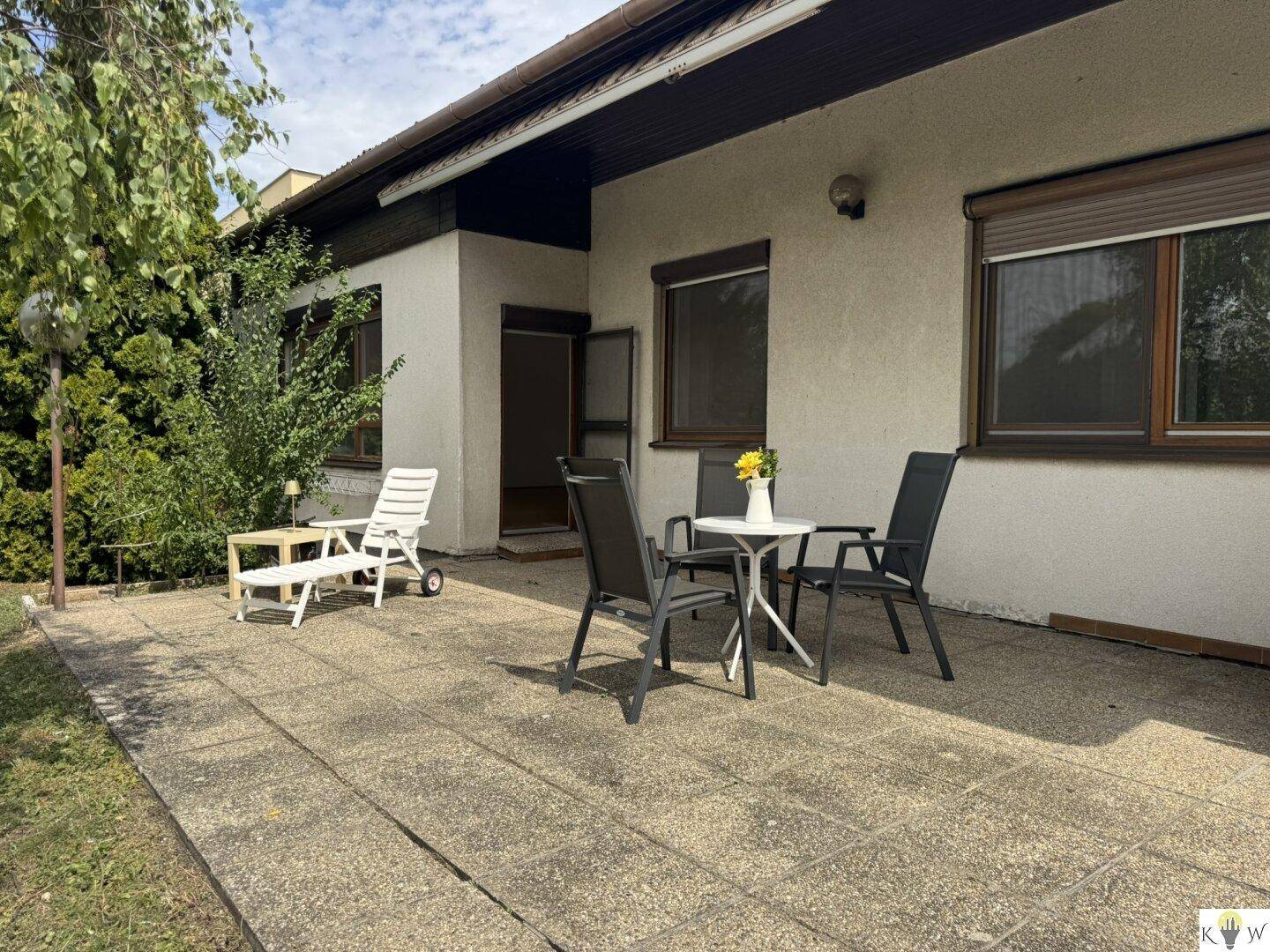 Gemütliche Terrasse mit Gartenmöbeln und Blick ins Grüne, perfekt für Mahlzeiten im Freien.