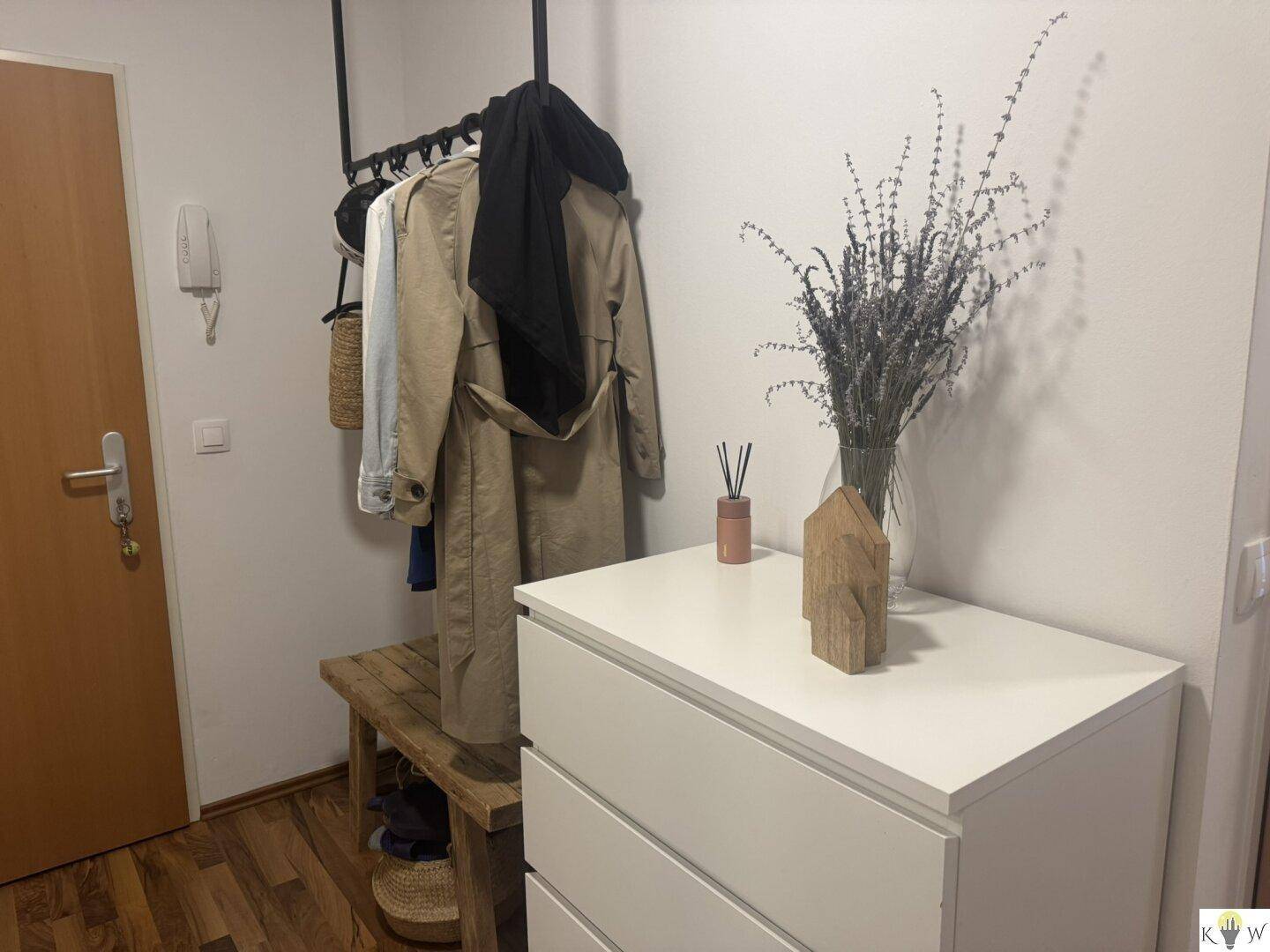 Eingangsbereich mit Garderobe, Kommode und Holzboden, einladend gestaltet.