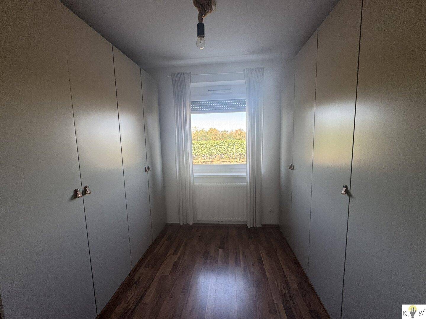 Kleiner Raum mit Einbauschränken und Fenster, ideal als Ankleidezimmer nutzbar.