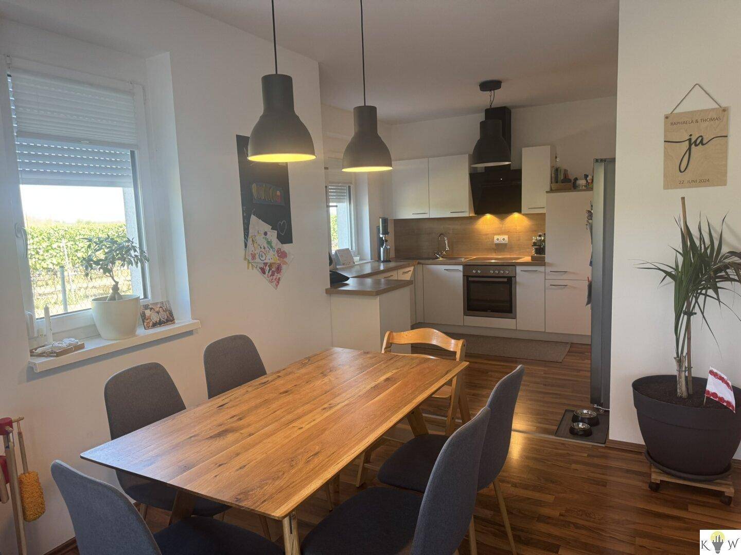 Essbereich mit Holztisch und Blick auf die moderne Küche, hell und offen gestaltet.