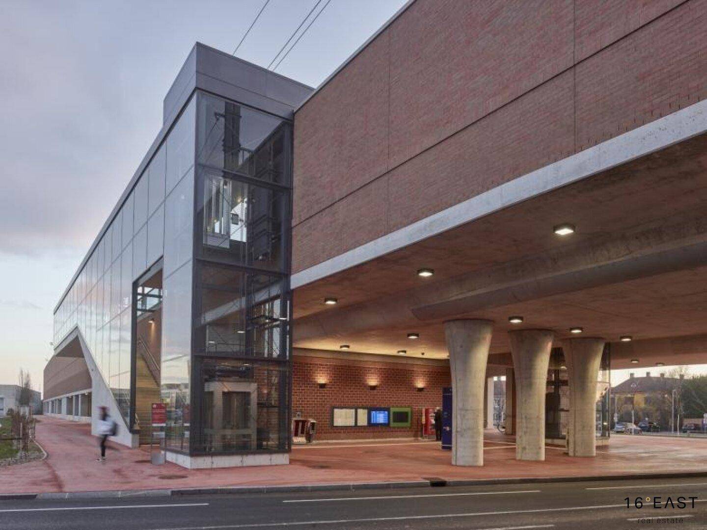 Modernes Gebäude mit Glasfassade, Ziegelmauerwerk und einem externen Glasaufzug.