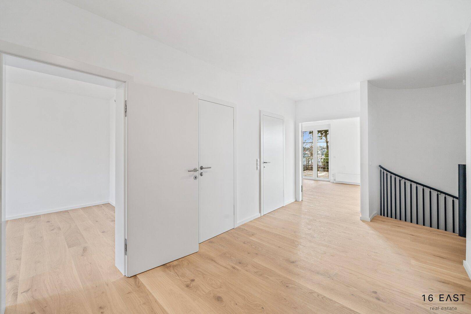 Geräumiger Flur mit Holzboden, Einbauschränken und Treppenzugang.