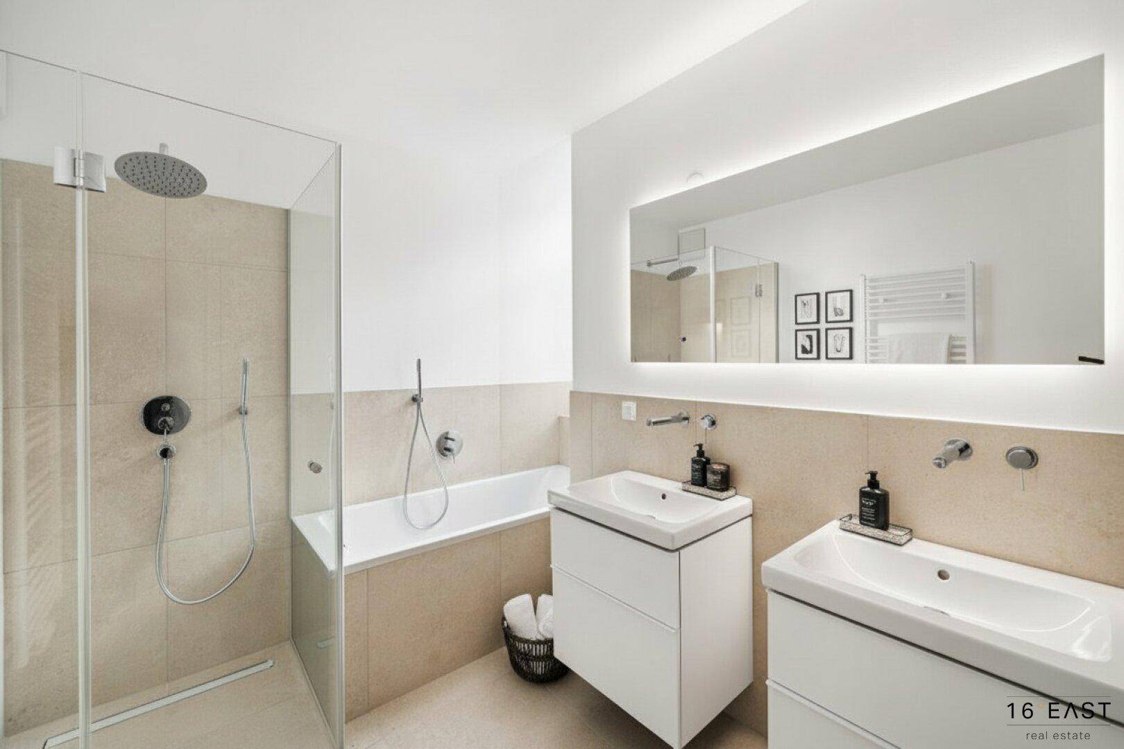 Modernes Badezimmer mit Doppelwaschbecken, Badewanne und begehbarer Dusche, ausgestattet mit hochwertigen Armaturen.