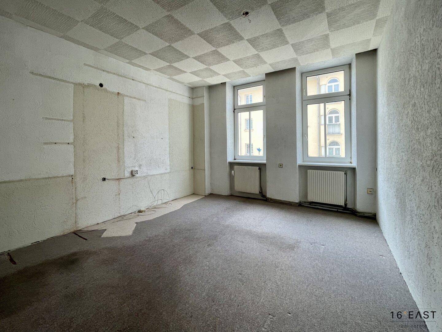 Unmöblierter Raum mit Teppichboden und strukturierten Wänden, bereit für neue Gestaltung.