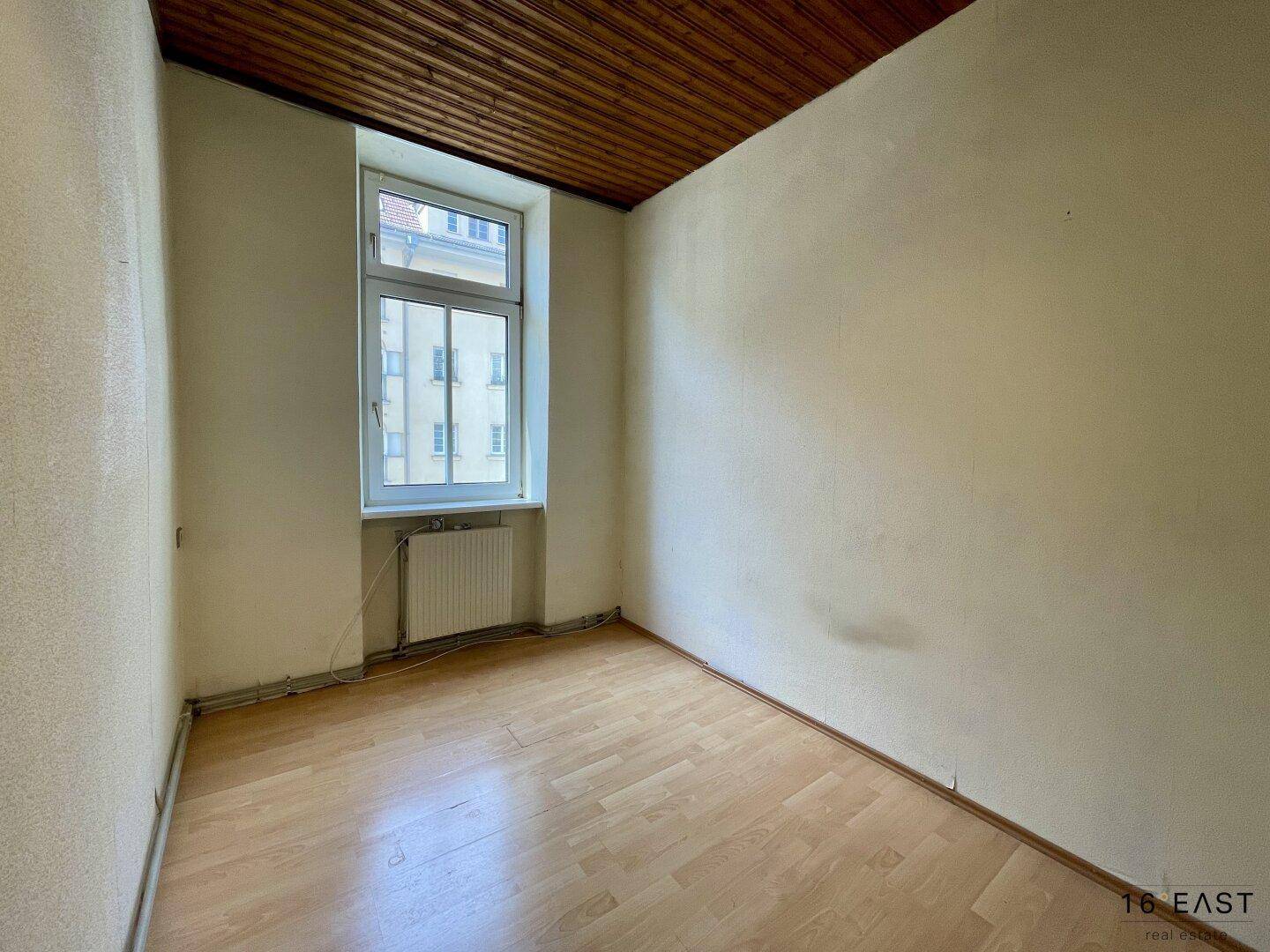 Kleines Zimmer mit Laminatboden und Holzdecke, ideal als Kinder- oder Arbeitszimmer.