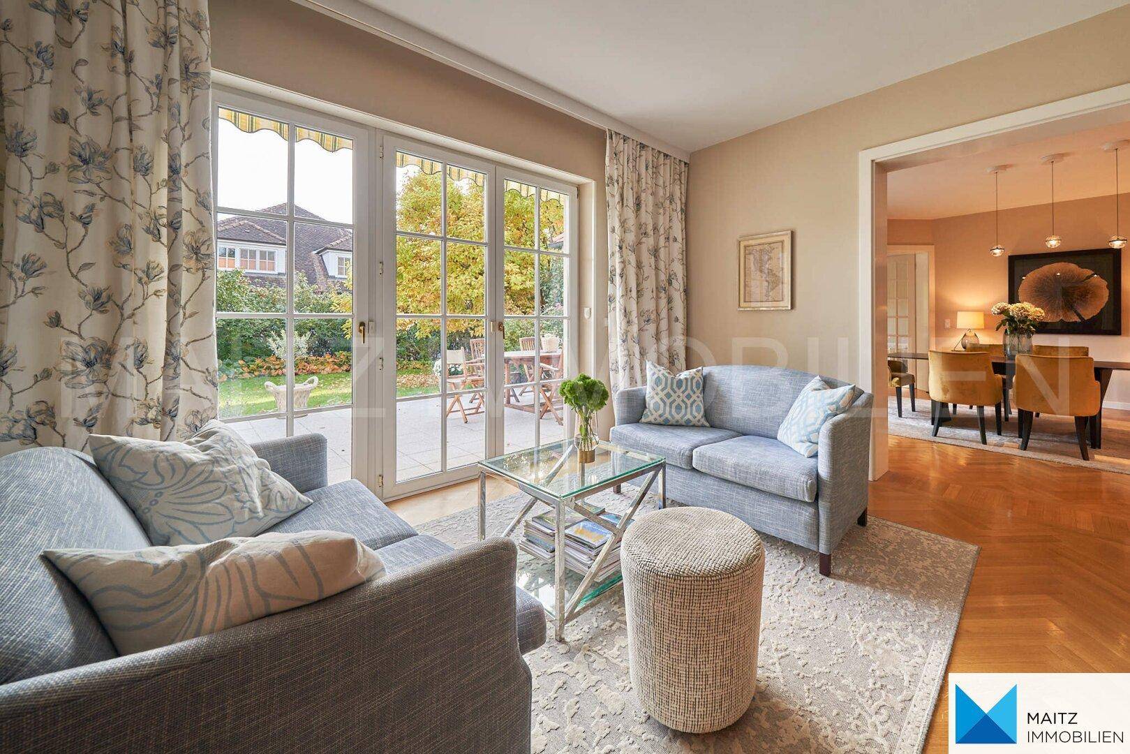 Helles Wohnzimmer mit bequemen Sofas, Parkettboden und direktem Zugang zum Garten.