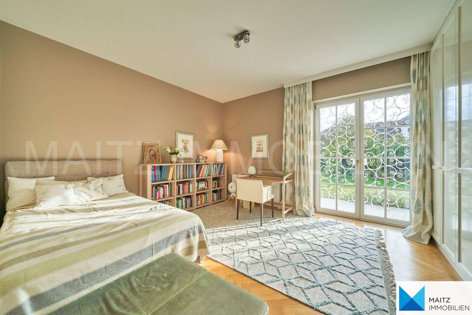 Schlafzimmer mit Doppelbett, Bücherregal und direktem Zugang zum Garten.