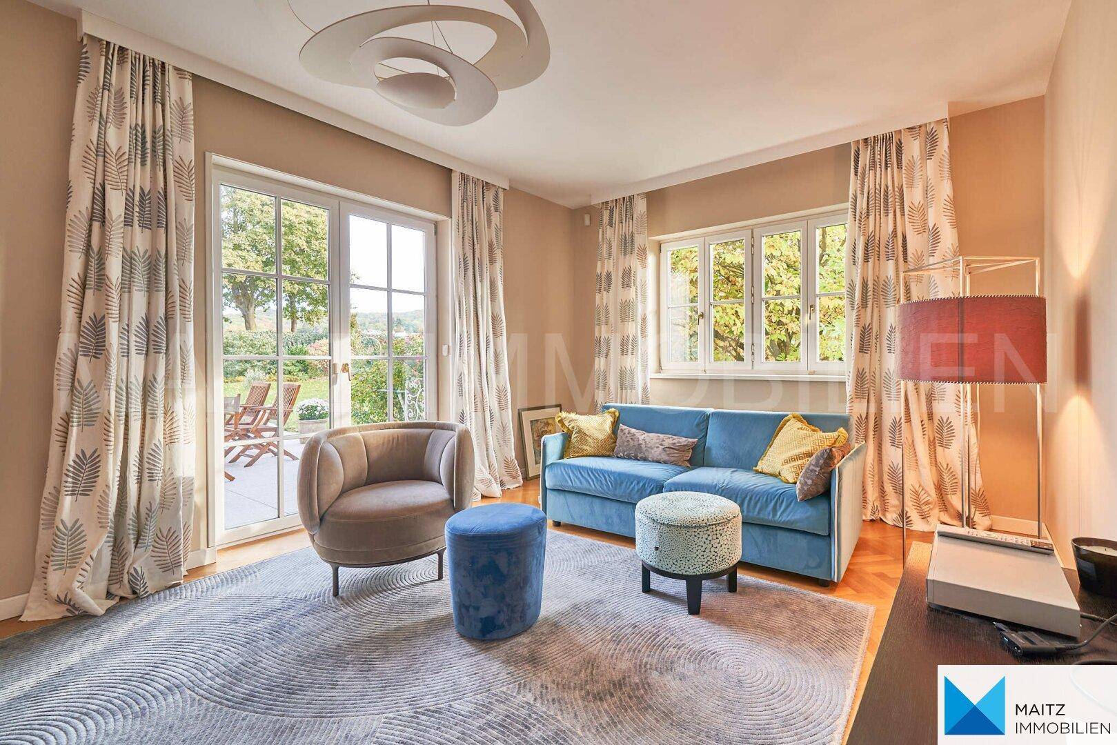 Gemütlicher Wohnbereich mit blauem Sofa, Teppich und Zugang zur Terrasse.