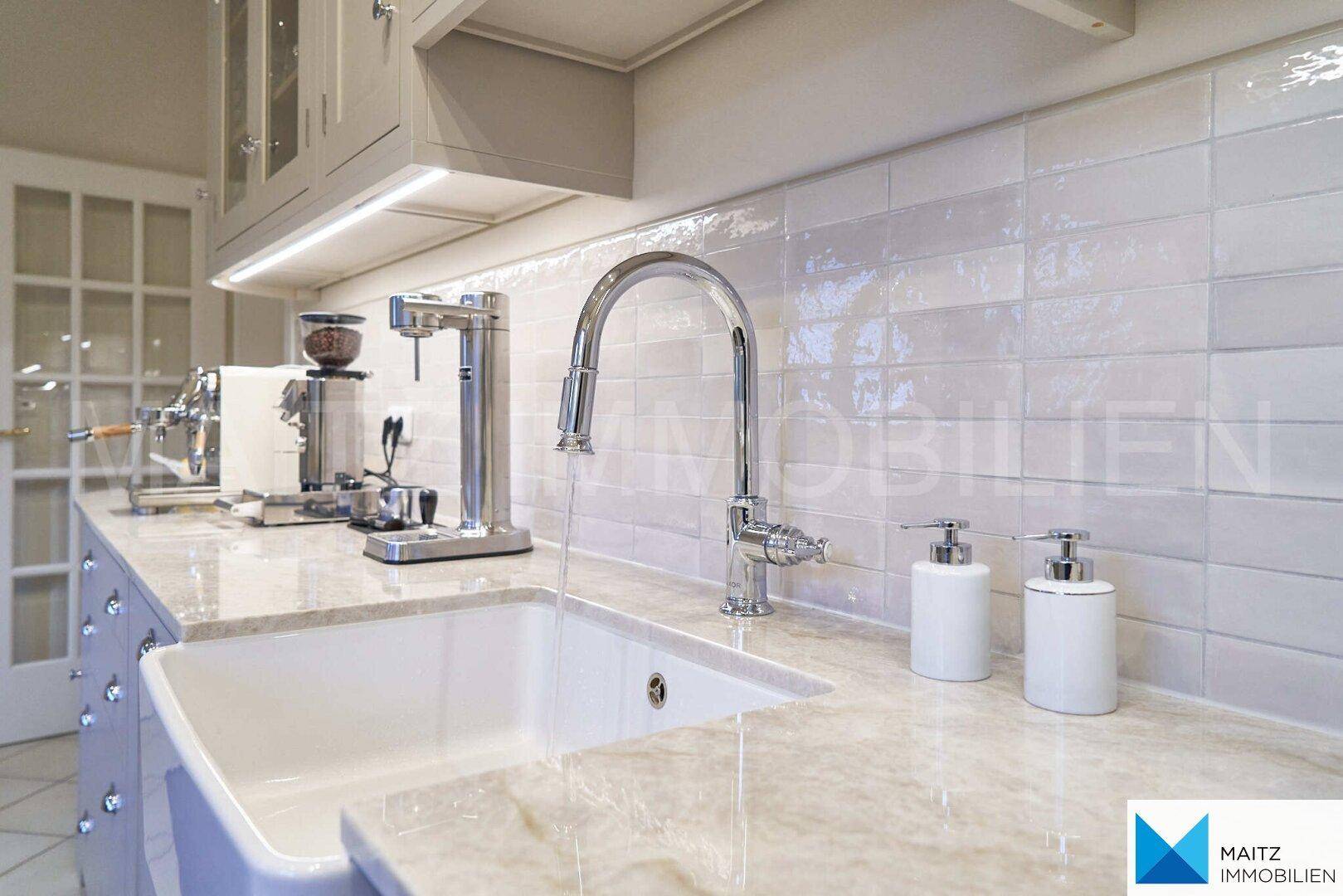 Detailansicht der Küchenspüle mit modernem Wasserhahn und heller Arbeitsplatte.