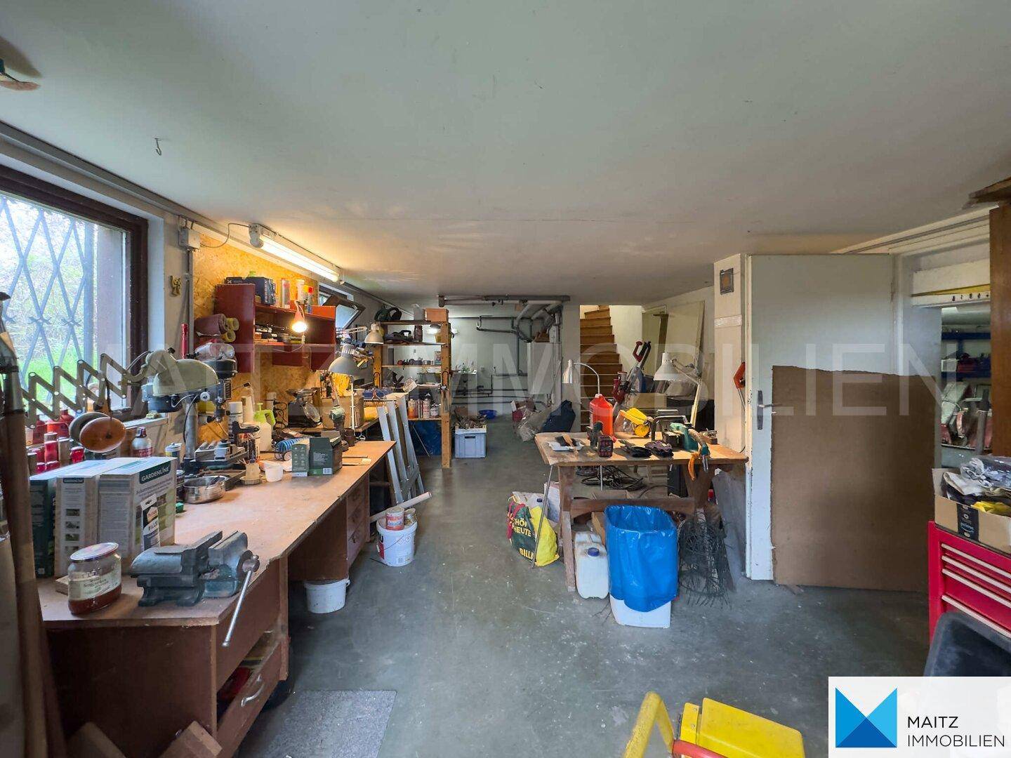 Geräumiger Werkstattraum im Untergeschoss mit Arbeitsflächen und viel Stauraum.